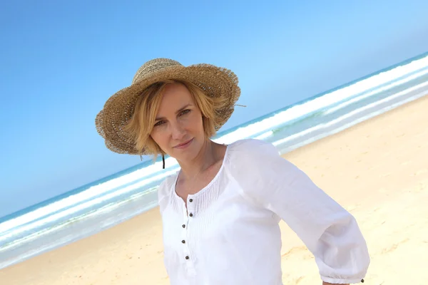 Γωνία πυροβολισμό γυναίκας σε ένα ψάθινο καπέλο σε μια όμορφη αμμώδη παραλία — Φωτογραφία Αρχείου