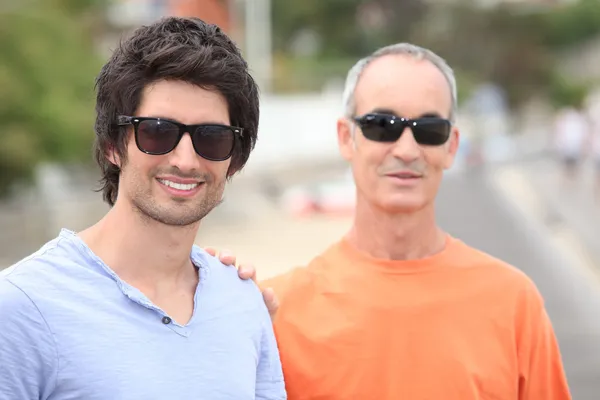 Dos hombres de diferentes generaciones con gafas de sol y camisetas —  Fotos de Stock