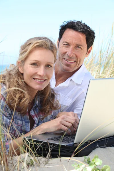 Par leende på laptop. — Stockfoto