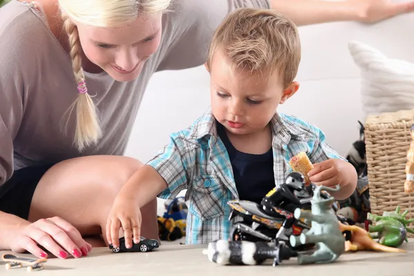 Mor och barn leker med leksaksbilar — Stockfoto