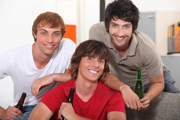 Tres amigos bebiendo cerveza en casa — Foto de Stock