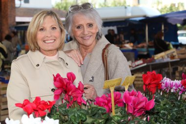 Mother and daughter at the market clipart