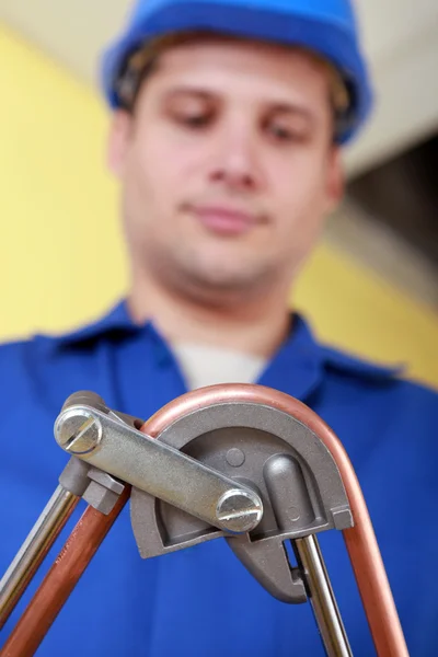 Encanador dobrando tubo de cobre — Fotografia de Stock