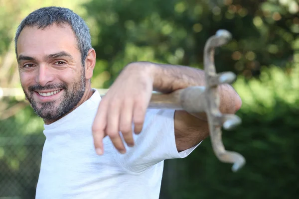 Tuinier met een hark over zijn schouders — Stockfoto