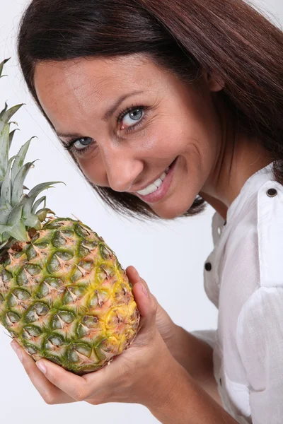 Linda senhora todos os sorrisos segurando abacaxi — Fotografia de Stock