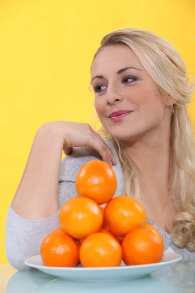 Blondin med apelsiner — Stockfoto