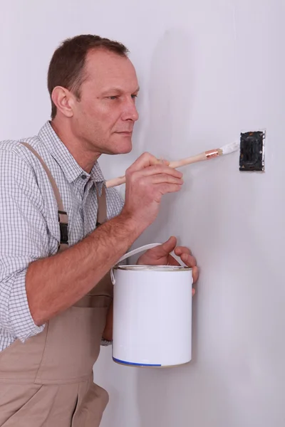Homem pintura em torno do interruptor de pintura — Fotografia de Stock