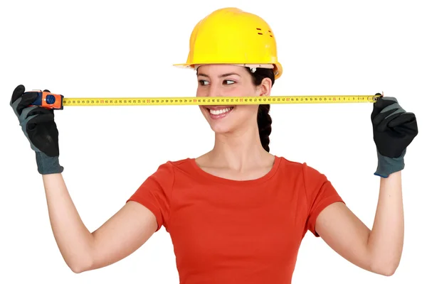 Tradeswoman extending a measuring tape — Stock Photo, Image