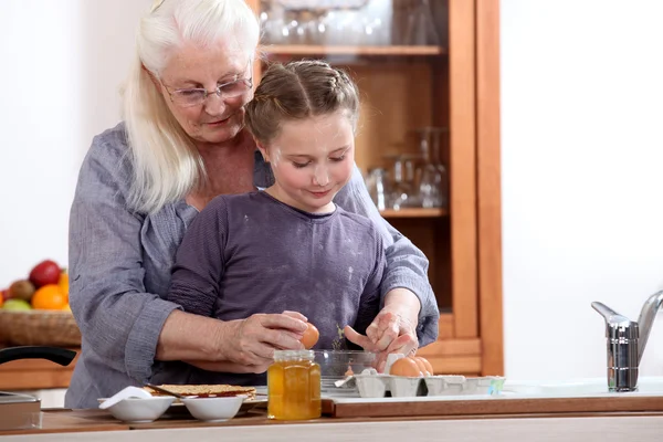 Маленькая девочка готовит с бабушкой — стоковое фото