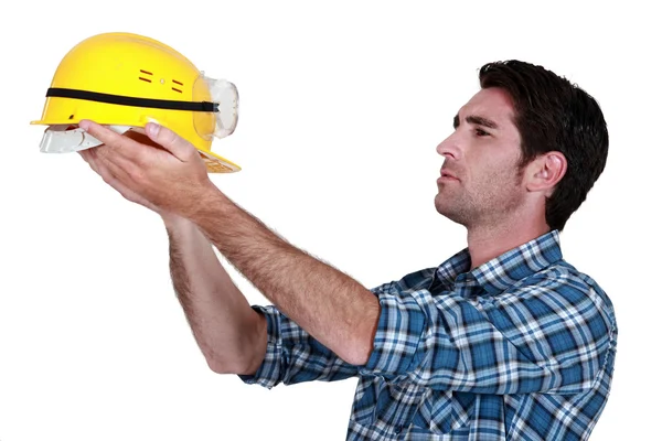 Homem segurando um capacete de construção — Fotografia de Stock