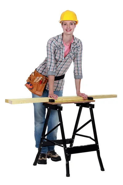 Tradeswoman leaning against a workbench — Stock Photo, Image