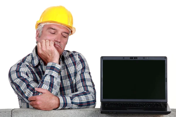 Artigiano anziano in posa accanto a un computer portatile — Foto Stock