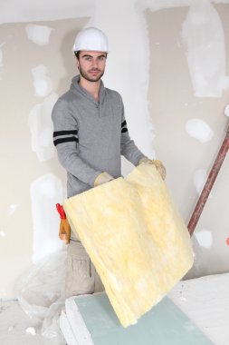 Worker handling square of insulation clipart