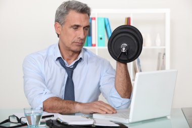 Businessman making exercises in his office clipart