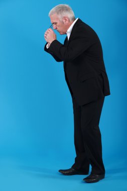 Businessman putting his eyeglasses on to look for an object clipart