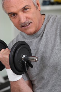 A mature man doing fitness with dumbbell clipart