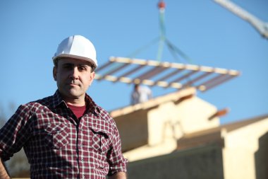 Foreman overseeing construction of house clipart