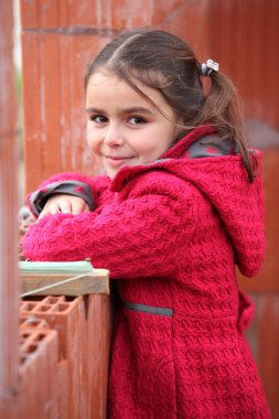 Cute little girl wearing a red coat clipart