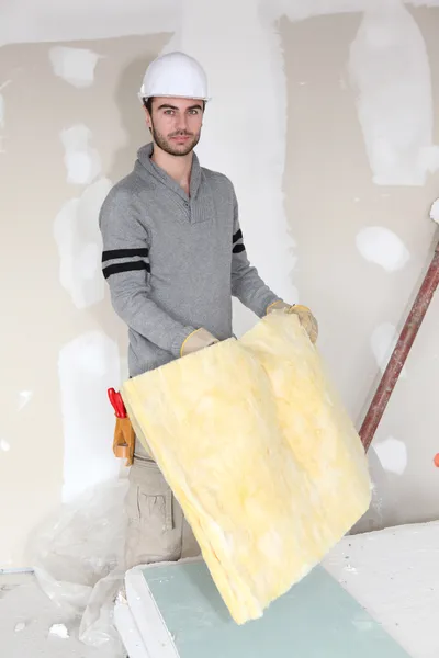 Worker handling square of insulation — Stock Photo, Image