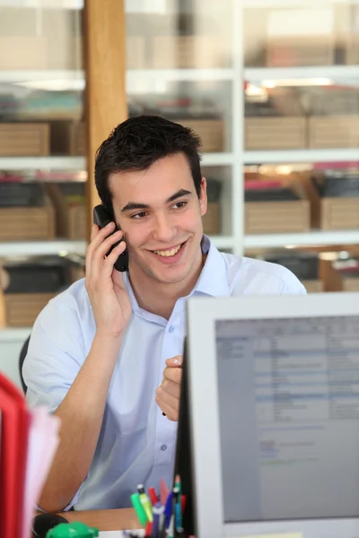 Manliga kontorist talar till kunden per telefon — Stockfoto