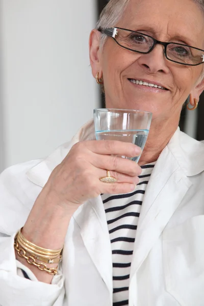 Seniorenvrouw drinkwater — Stockfoto