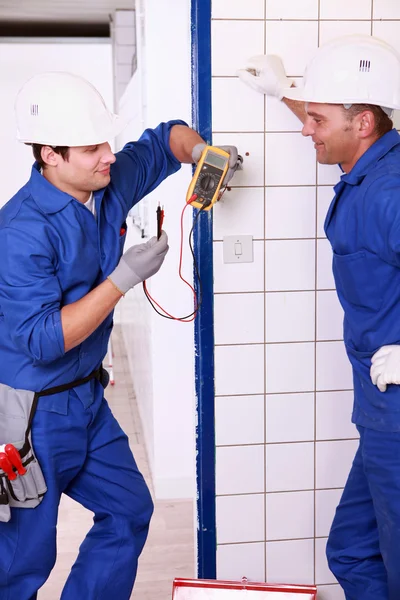 Dvě elektrikáři diskutovat voltmetr — Stock fotografie