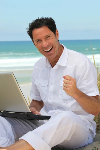 Człowiek szczęśliwy, praca na plaży. — Zdjęcie stockowe