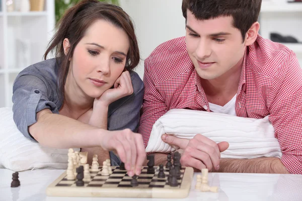Um casal de adolescentes a jogar xadrez . — Fotografia de Stock