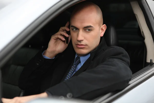 Uomo d'affari che usa un telefono in macchina — Foto Stock