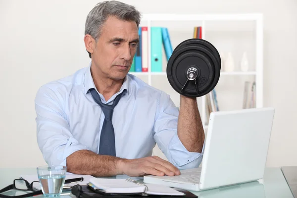 Affärsman att göra övningar i hans kontor — Stockfoto