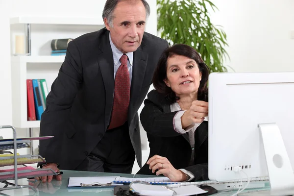 Volwassen bedrijf paar op een computer — Stockfoto