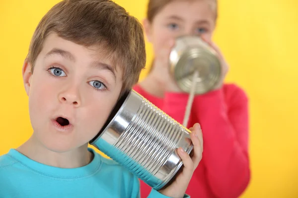 Barn kommunicerar med plåtburkar — Stockfoto