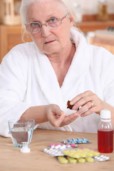 Older woman taking medicine — Stock Photo, Image