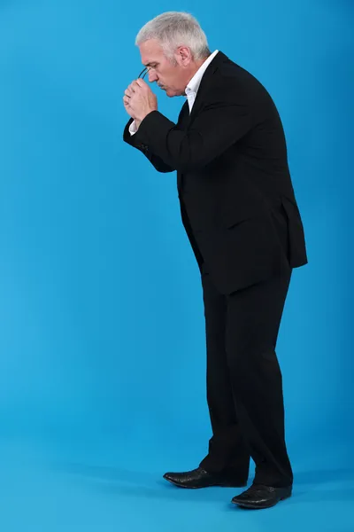 Businessman putting his eyeglasses on to look for an object — Stock Photo, Image