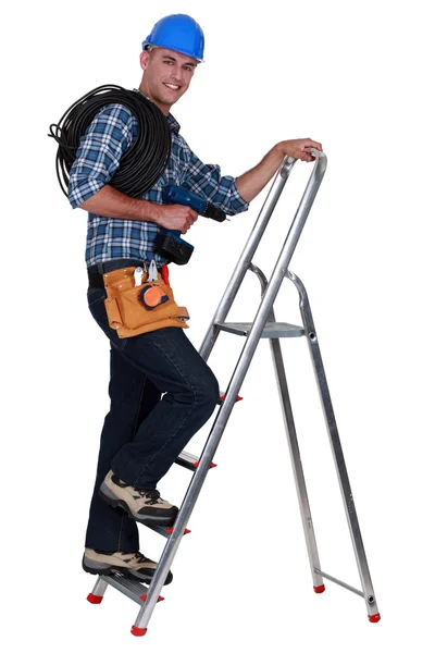 En elektriker klättring en stege. — Stockfoto
