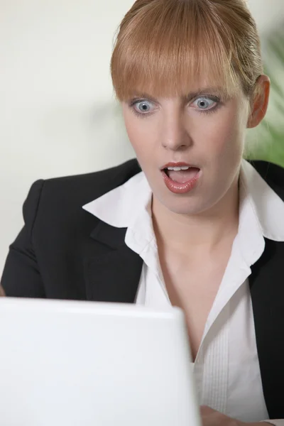 Mulher chocada olhando para laptop — Fotografia de Stock