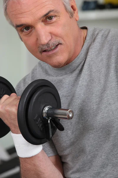 Dojrzały człowiek robi fitness z hantle — Zdjęcie stockowe