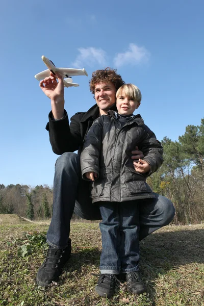 Vader en zoon spelen met een vliegtuig — Stockfoto