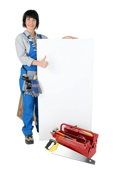 Craftsperson fêmea com caixa de ferramentas e placa branca — Fotografia de Stock