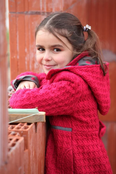 Söt liten flicka klädd i röd jacka — Stockfoto