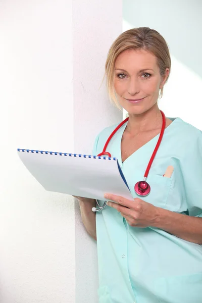 Blond female nurse leaning against wall — Stock Photo, Image