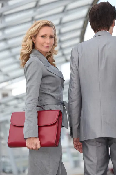 Mujer llevando maletín con colega —  Fotos de Stock