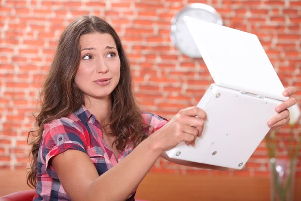Young woman scared of her laptop — Stock Photo, Image
