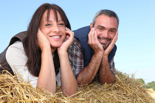 Bauer und Frau liegen im Heu — Stockfoto
