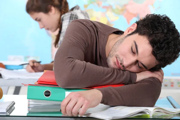 Junger Mann schläft während einer Uni-Vorlesung — Stockfoto