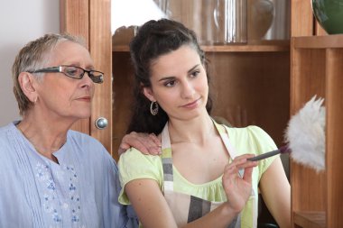 Young woman helping senior lady with the cleaning clipart