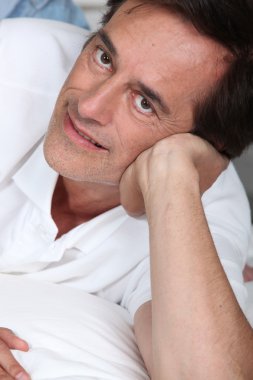 Close up of a mature man relaxing indoors clipart