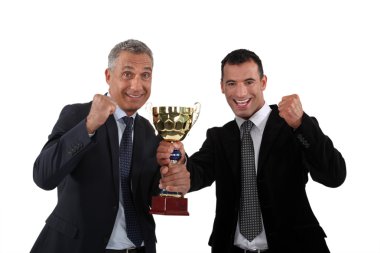 Cheerful businessmen holding a golden cup clipart