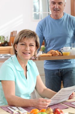 Man bringing his wife breakfast on a tray clipart