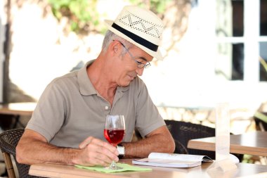 Man sat reading book on terrace clipart